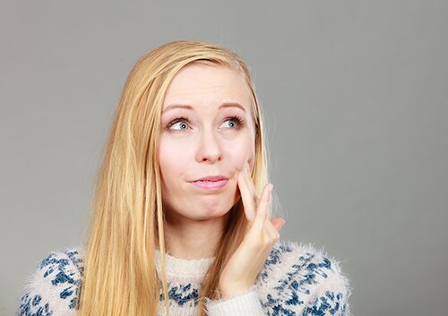 Woman having toothache touching her cheek